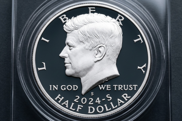 A 2024-S Kennedy Half Dollar proof coin with a deep cameo finish, housed in a square clear protective acrylic capsule against a black background.